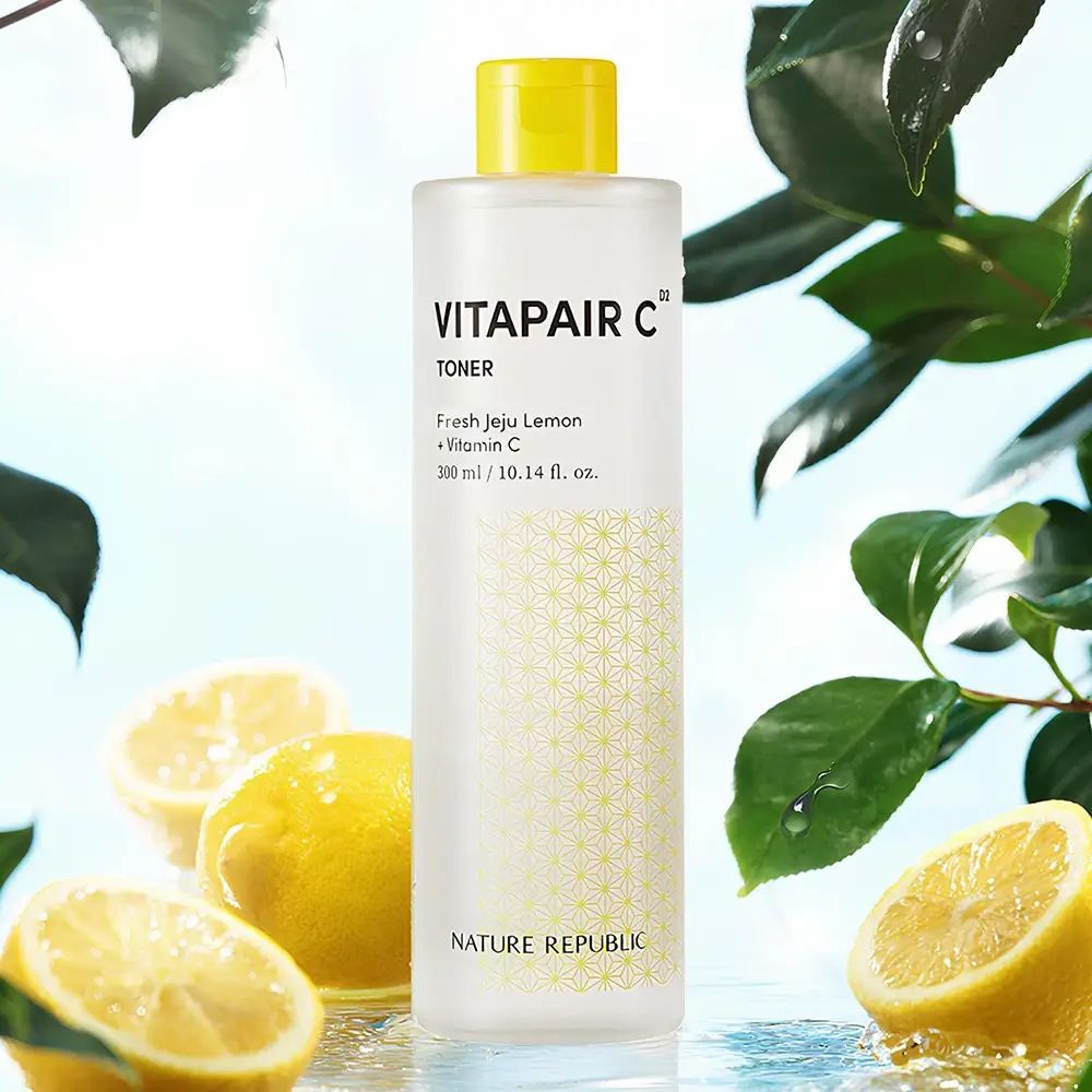 Transparente Flasche mit gelbem Deckel, umgeben von Zitronen und Blättern. Aufschrift: VITAPAIR C Toner. Marke: NATURE REPUBLIC.