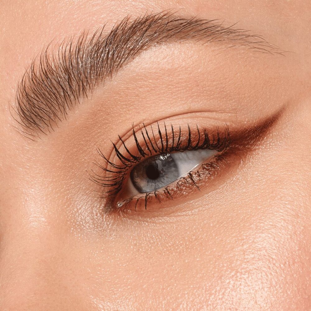 Nahaufnahme eines Auges mit braunem Kajalstrich. Wimpern sind getuscht.