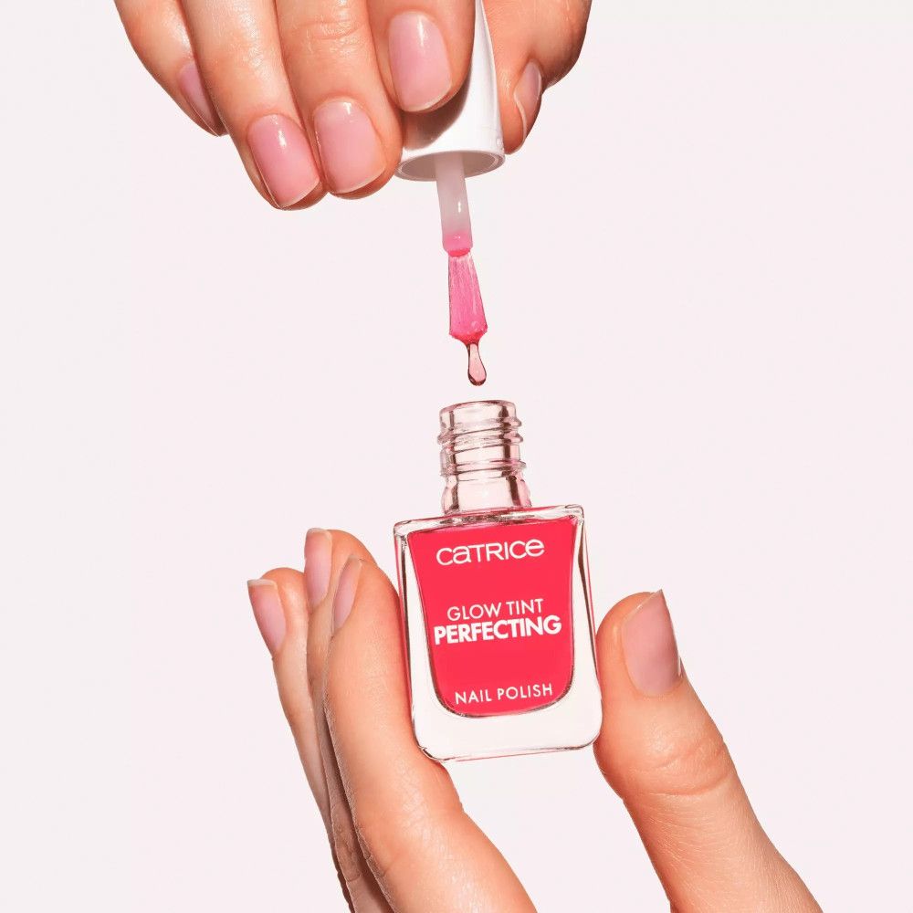 Nagellackflasche mit rotem Inhalt. Pinsel tropft. Aufschrift: Catrice, Glow Tint Perfecting, Nail Polish.
