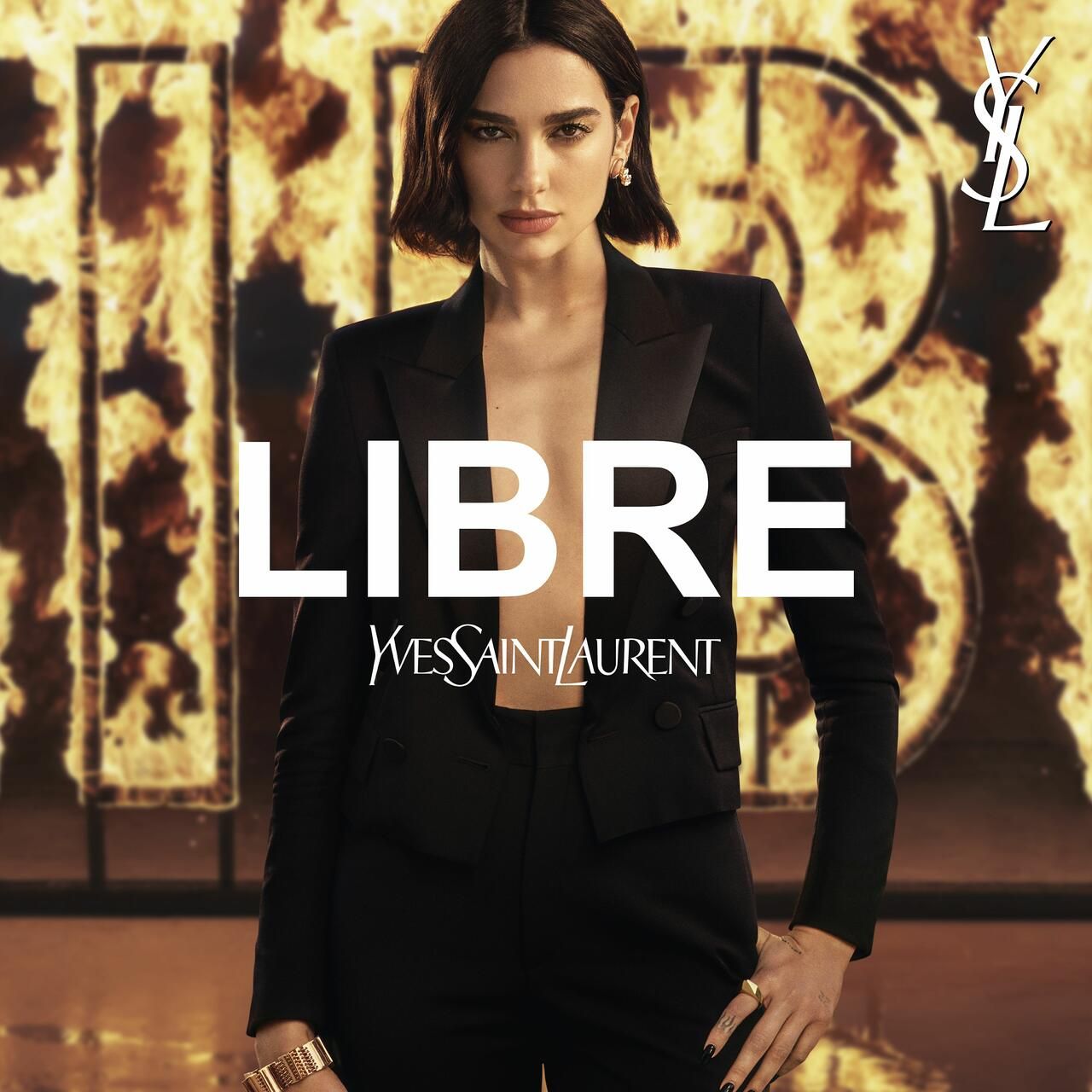 Dua Lipa vor flammendem Hintergrund. Großes LIBRE-Logo und Yves Saint Laurent-Logo.