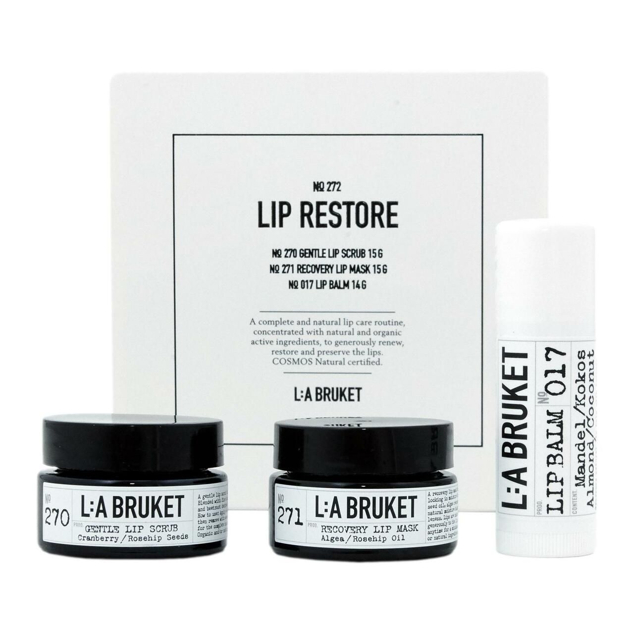 L:A Bruket Lip Restore Kit. Enthält Lip Scrub, Lip Mask und Lip Balm. Auf der Verpackung steht COSMOS NATURAL. Die Produkte sind in einer Box angeordnet.