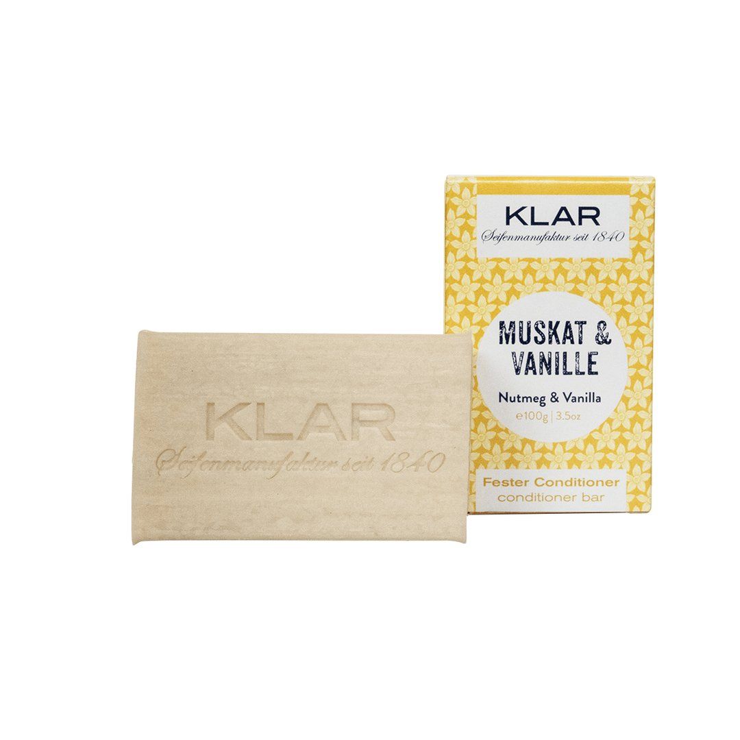 Fester Conditioner und Verpackung. Conditioner mit Klar-Logo. Verpackung mit floralem Muster und Text.