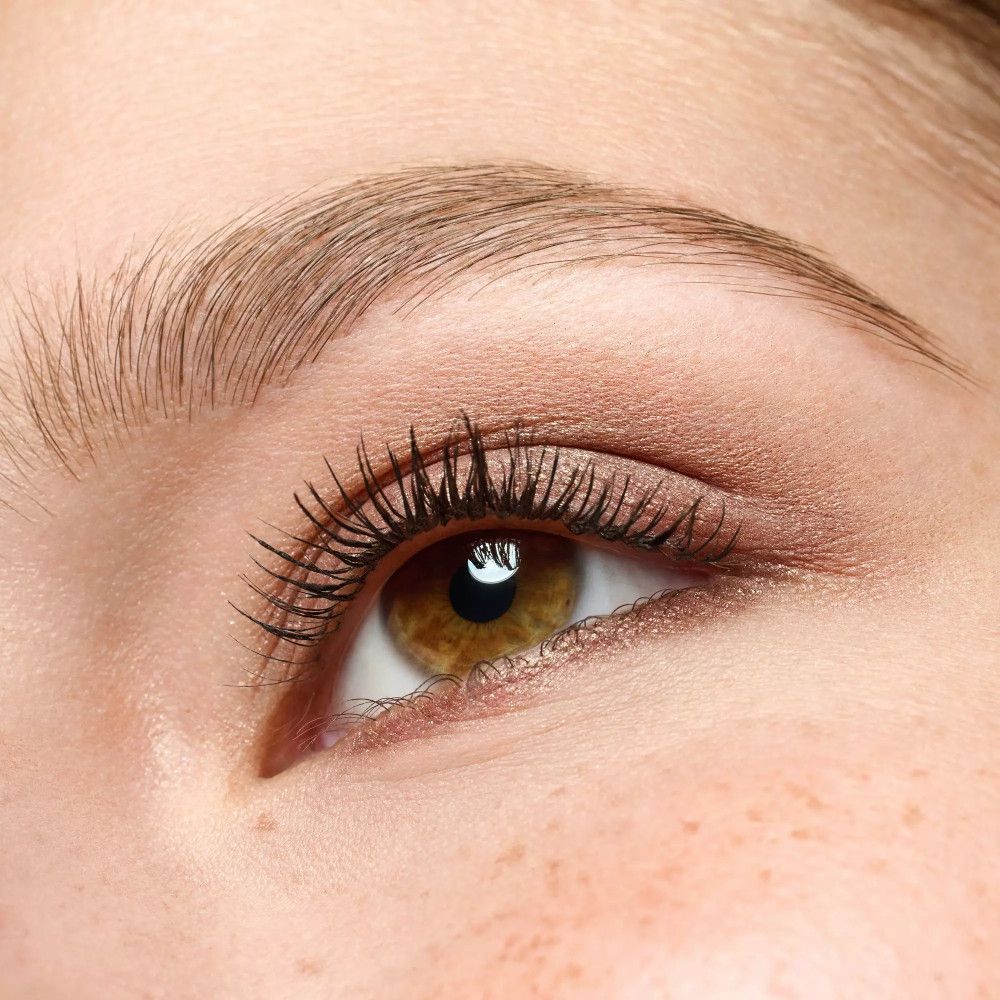 Nahaufnahme eines Auges mit braunem Lidschatten und Wimperntusche.