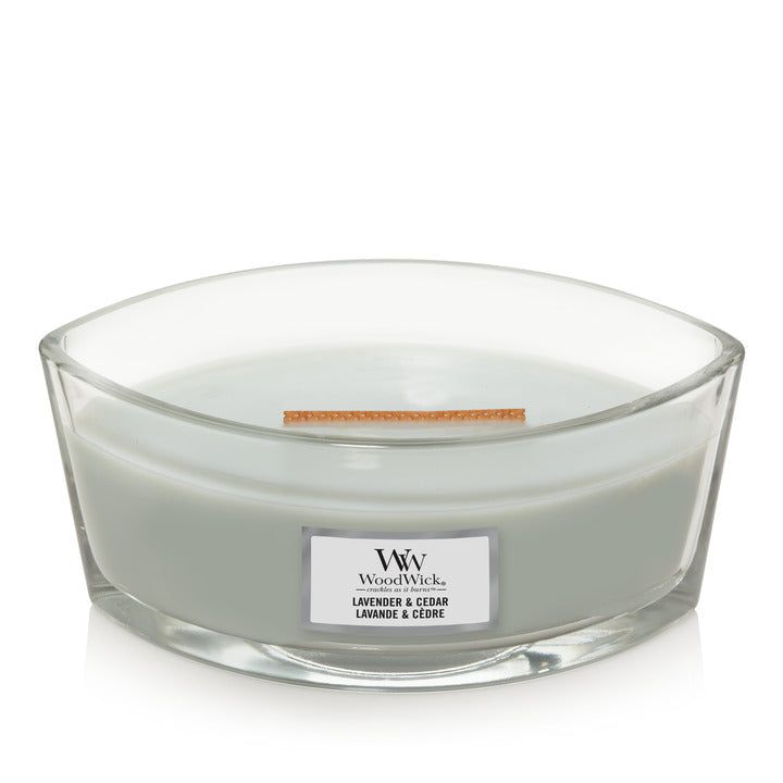 Ellipsenförmige Kerze in Glasbehälter. Aufkleber mit "WoodWick" und "Lavender & Cedar".