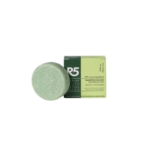 Grüner, runder Shampoo-Block und Schachtel mit Text. Vegan. Auf weißem Hintergrund.