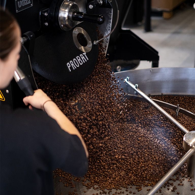 Kaffeebohnen fallen aus einer Kaffeeröstmaschine.