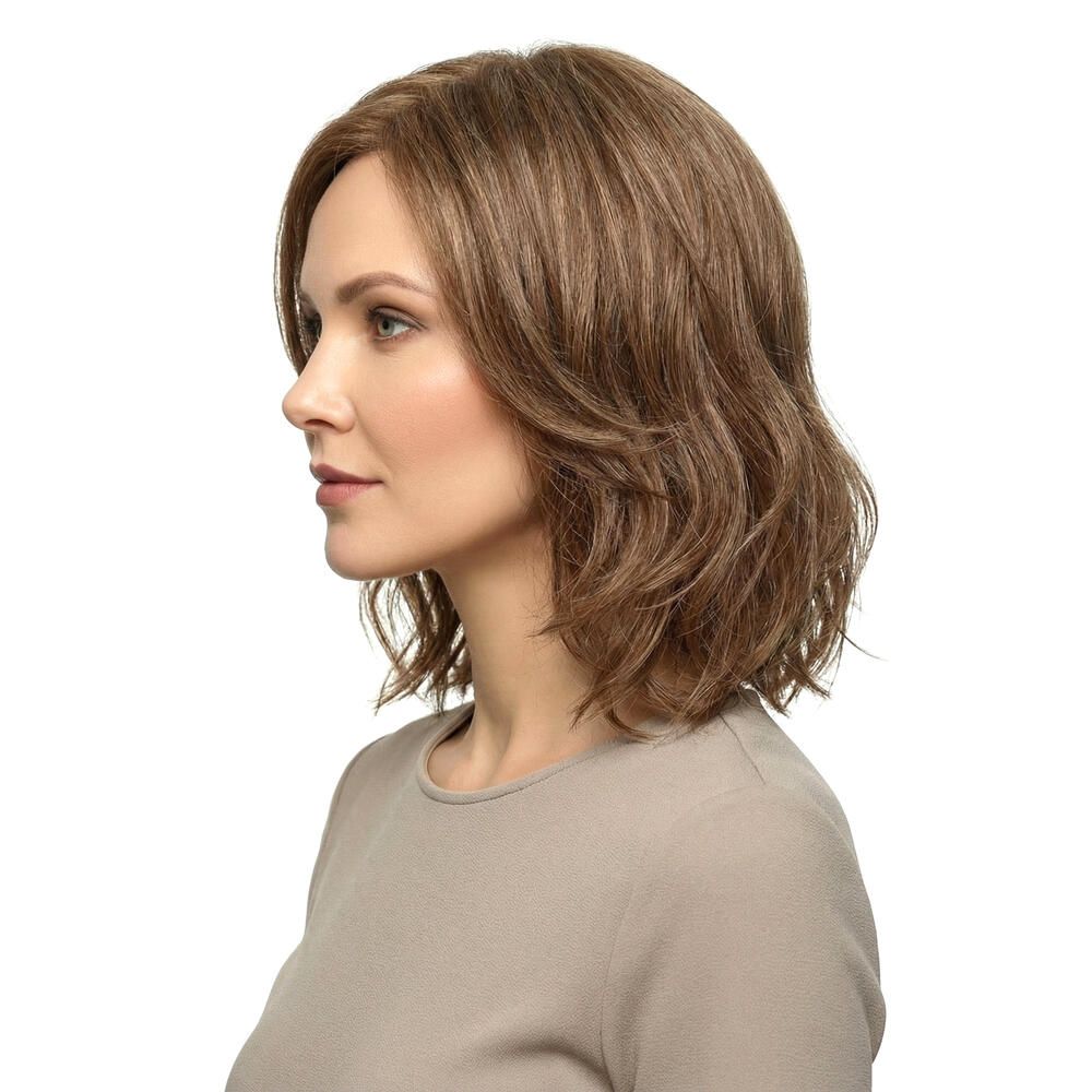 Perücke Lilie von trendhair. Kurze, gewellte, braune Haare. Frau mit beigem Oberteil. Seitenansicht.