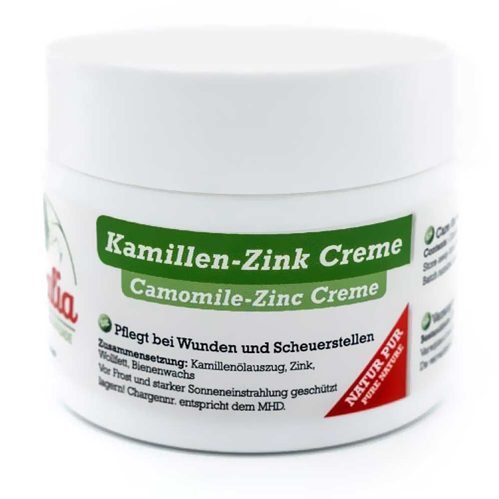 Weiße Dose mit grünem Etikett. Aufschrift: Kamillen-Zink Creme, Camomile-Zinc Creme. Rotes Logo: Natur Pur.