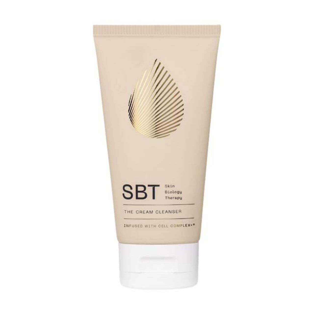 Beigefarbene Tube mit weißem Verschluss. Aufschrift: SBT Skin Biology Therapy, The Cream Cleanser. Goldfarbenes Tropfendesign.