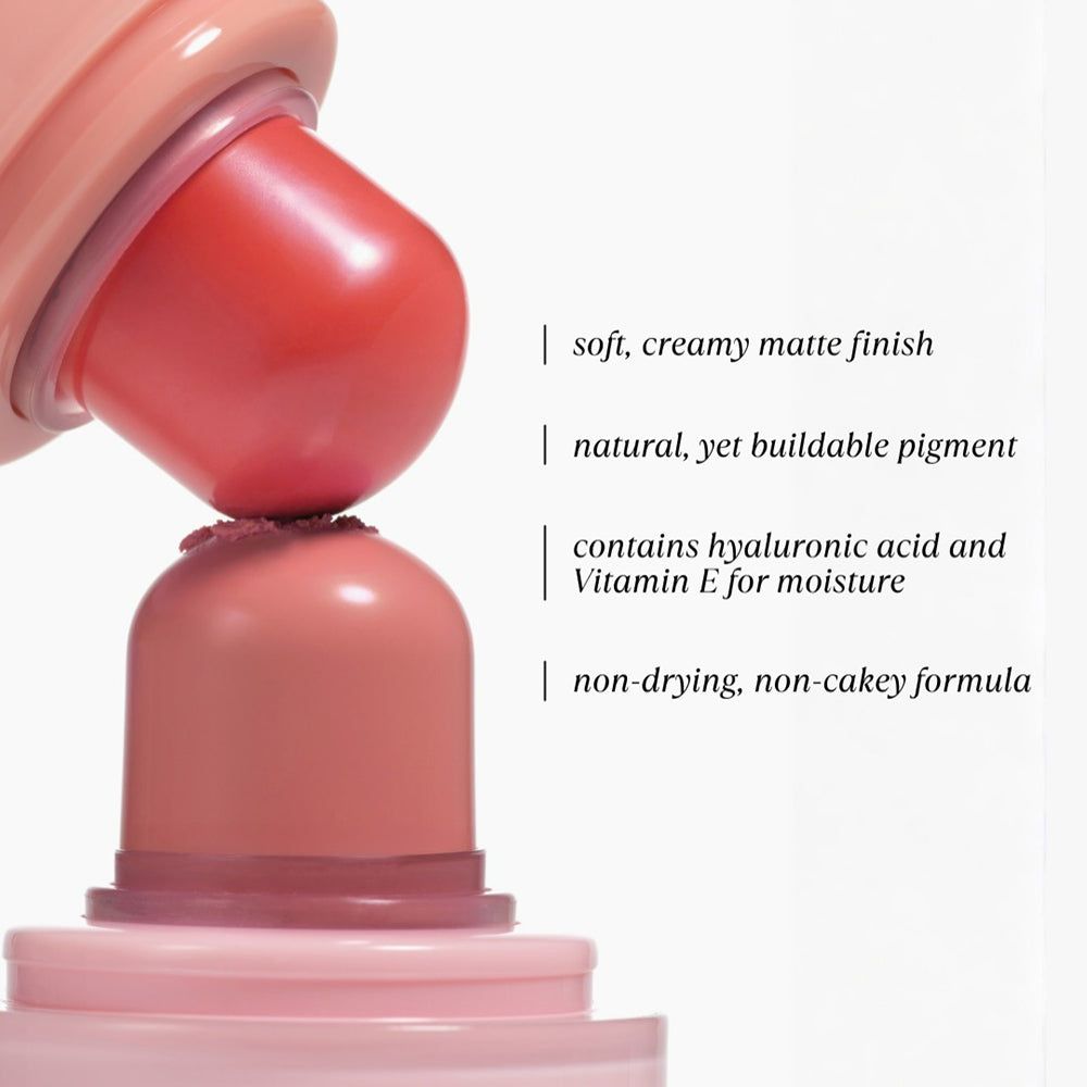 Nahaufnahme eines rosa Lippen- und Wangenbalms. Text: "weiches, cremiges mattes Finish", "natürliches, aber aufbaubares Pigment".