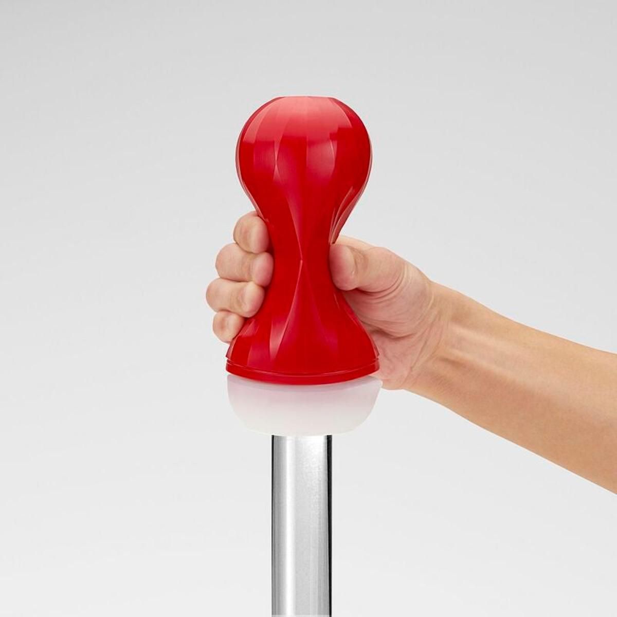 Rotes, längliches Produkt, gehalten von einer Hand. Unterteil weiß, Oberteil rot. Auf einem Metallstab.