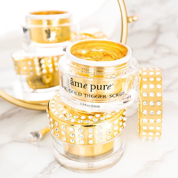 Meerdere potjes met goudkleurige scrub. Opschrift: âme pure 24K GOLD DIGGER SCRUB. Gouden spatel.