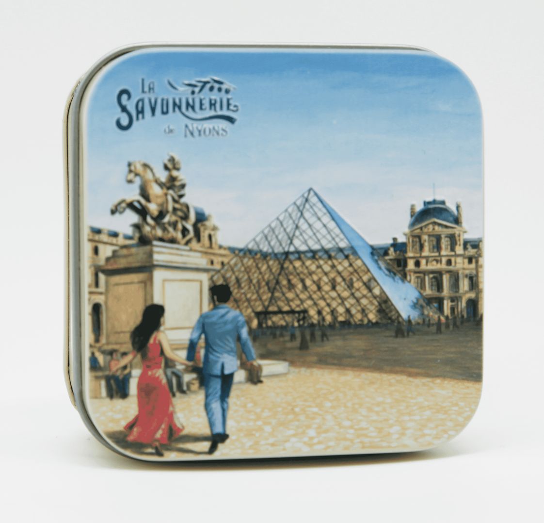 Metallbox mit Bild von Paris. "La Savonnerie de Nyons" Schriftzug. Quadratische Form, abgerundete Ecken. Szene mit Pyramide.