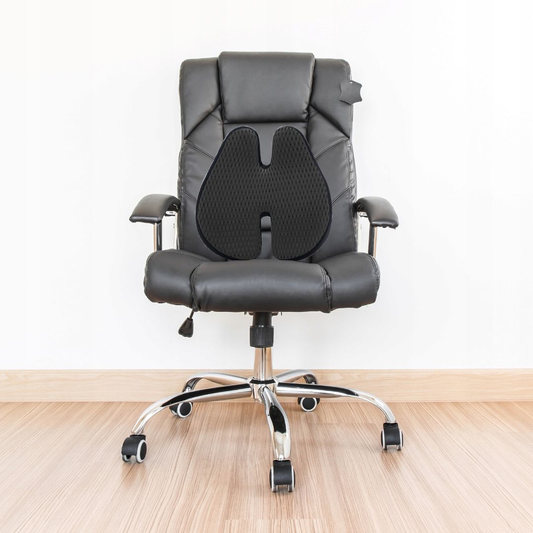 Schwarzes ergonomisches Sitzkissen mit Hohlkreuz-Design, platziert auf einem Bürostuhl.