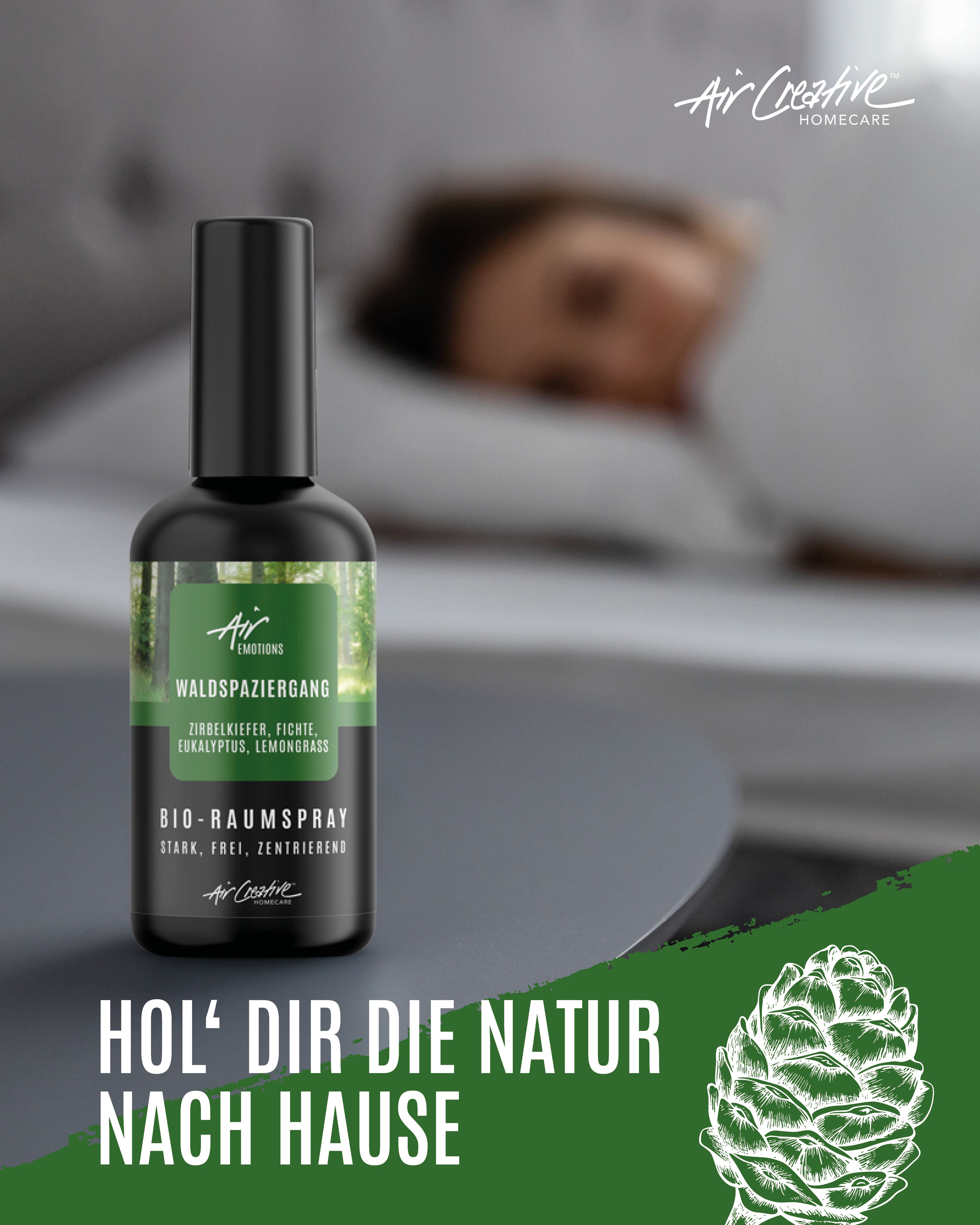 Schwarze Sprühflasche mit Etikett. Text: BIO-Raumspray Waldspaziergang. Im Hintergrund eine Person im Bett.