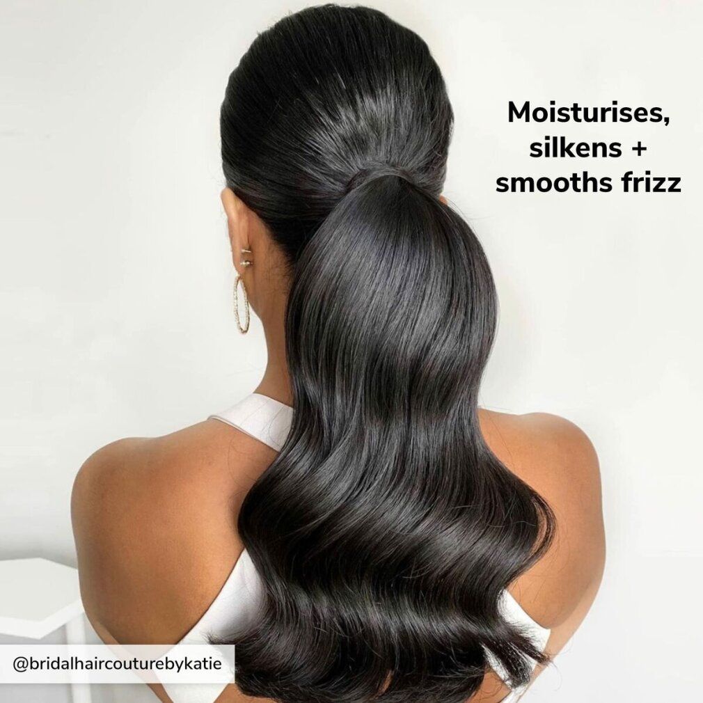 Dunkles, glänzendes Haar in einem Pferdeschwanz. Text: "Moisturises, silkens + smooths frizz".
