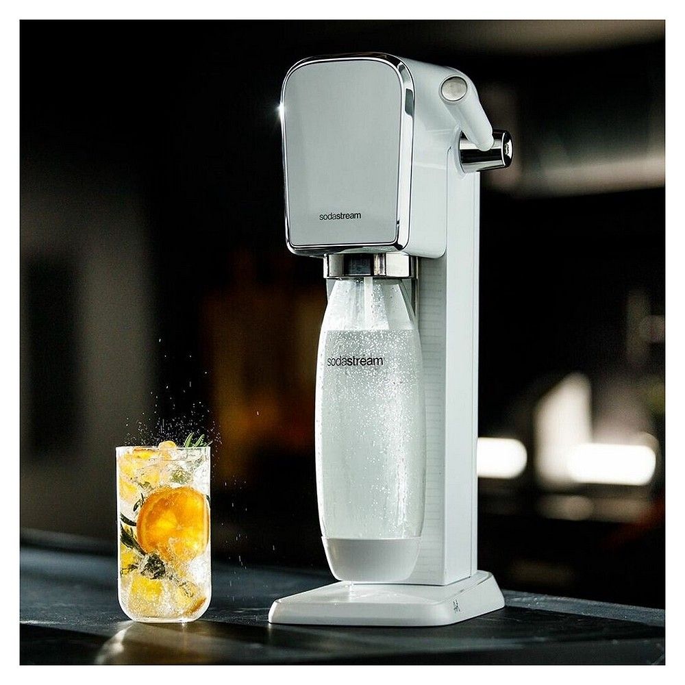SodaStream Art weißer Wassersprudler sprudelt Wasser in ein Glas mit Zitrone.