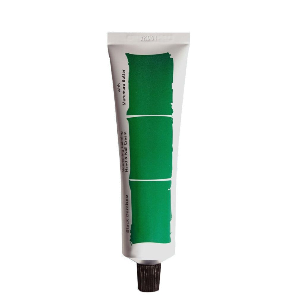 Weiße Tube mit schwarzem Deckel, beschriftet mit 'Black Bamboo Nourishing Calming Hand & Nail Cream'.