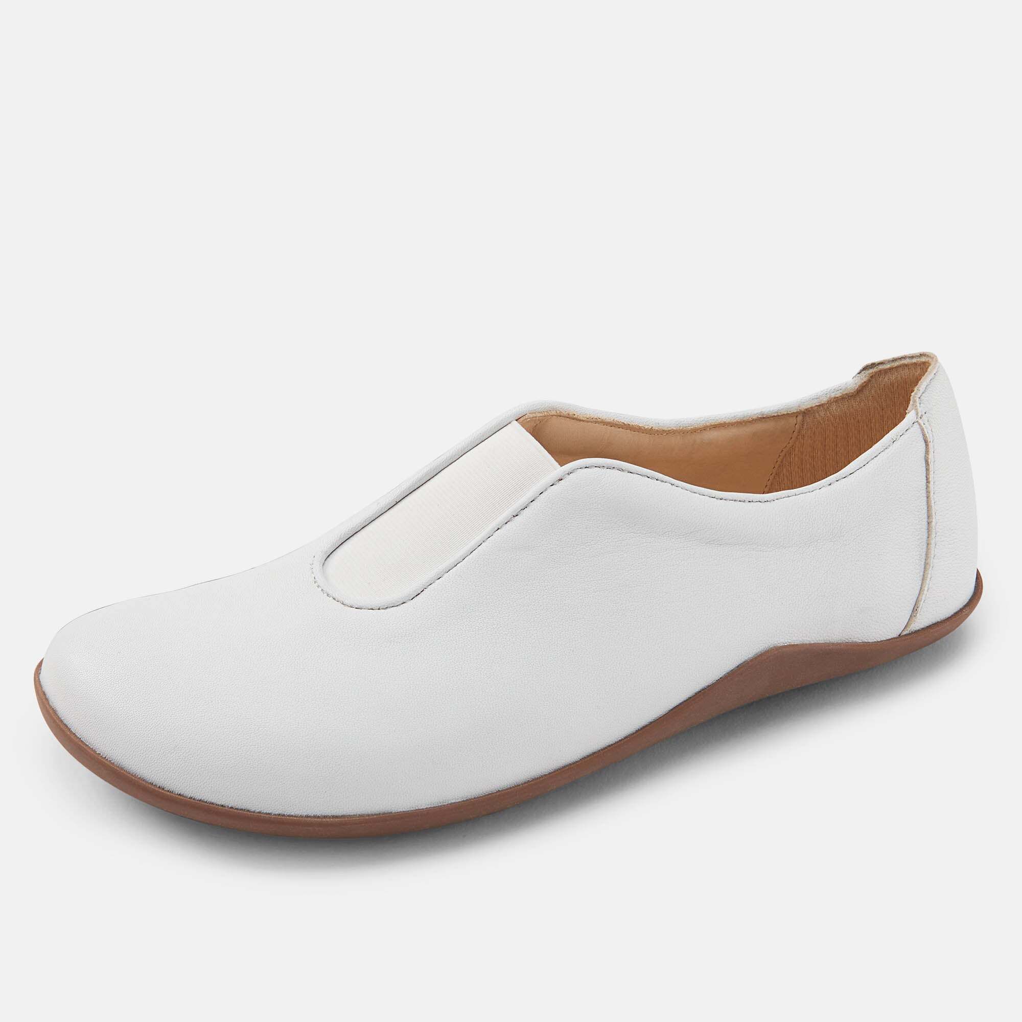 Ein weißer Damen-Slipper aus Leder mit brauner Sohle, von der Seite.