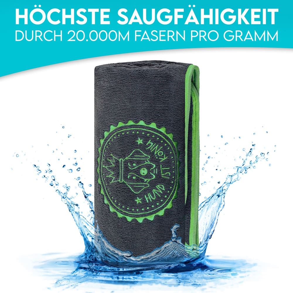 Graues Hundehandtuch mit grüner Umrandung, im Wasser. Text: Höchste Saugfähigkeit.