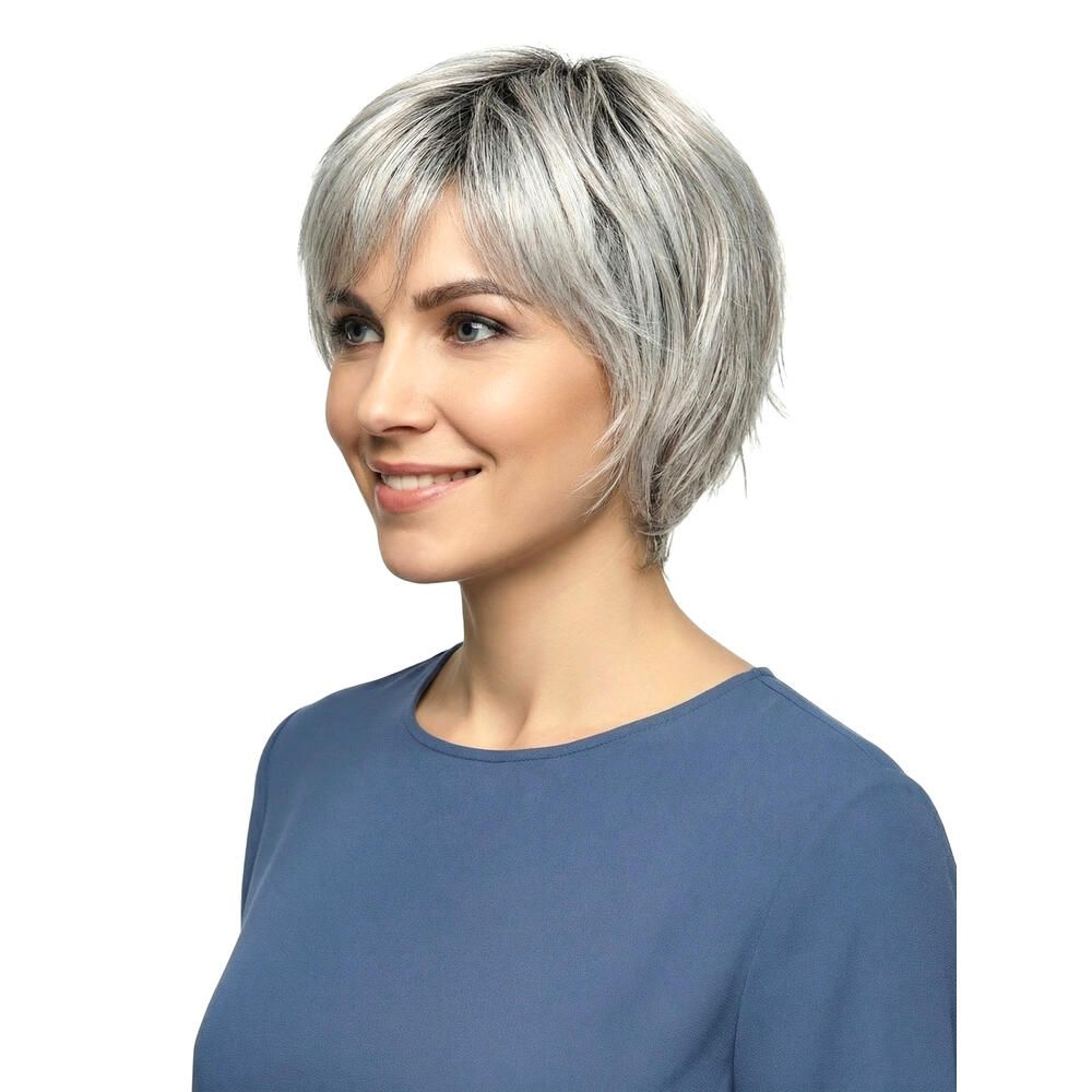 Kurzhaarperücke, grau-meliert, mit Pony, von einer Frau getragen. Die Frau lächelt und trägt ein blaues Oberteil.