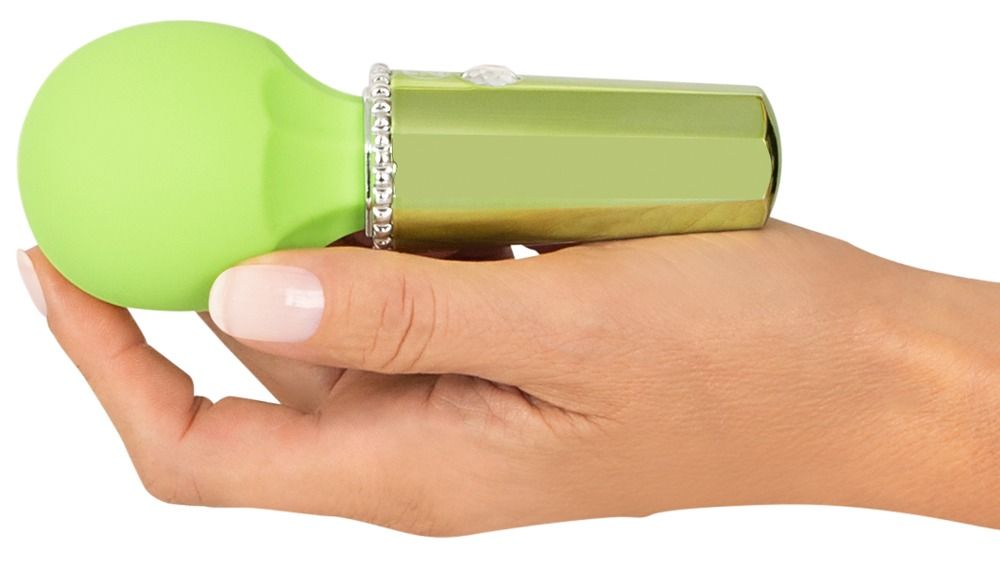 Grüner Wellness-Artikel in einer Hand gehalten. Silberfarbener Schaft mit Glitzersteinen. Runde Spitze sichtbar.