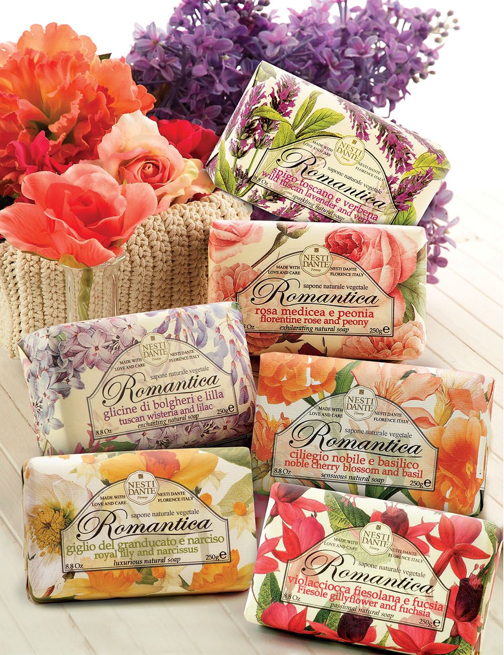 Mehrere Seifenstücke mit floralen Designs. Die Verpackung zeigt den Markennamen Romantica und verschiedene Blumennamen.