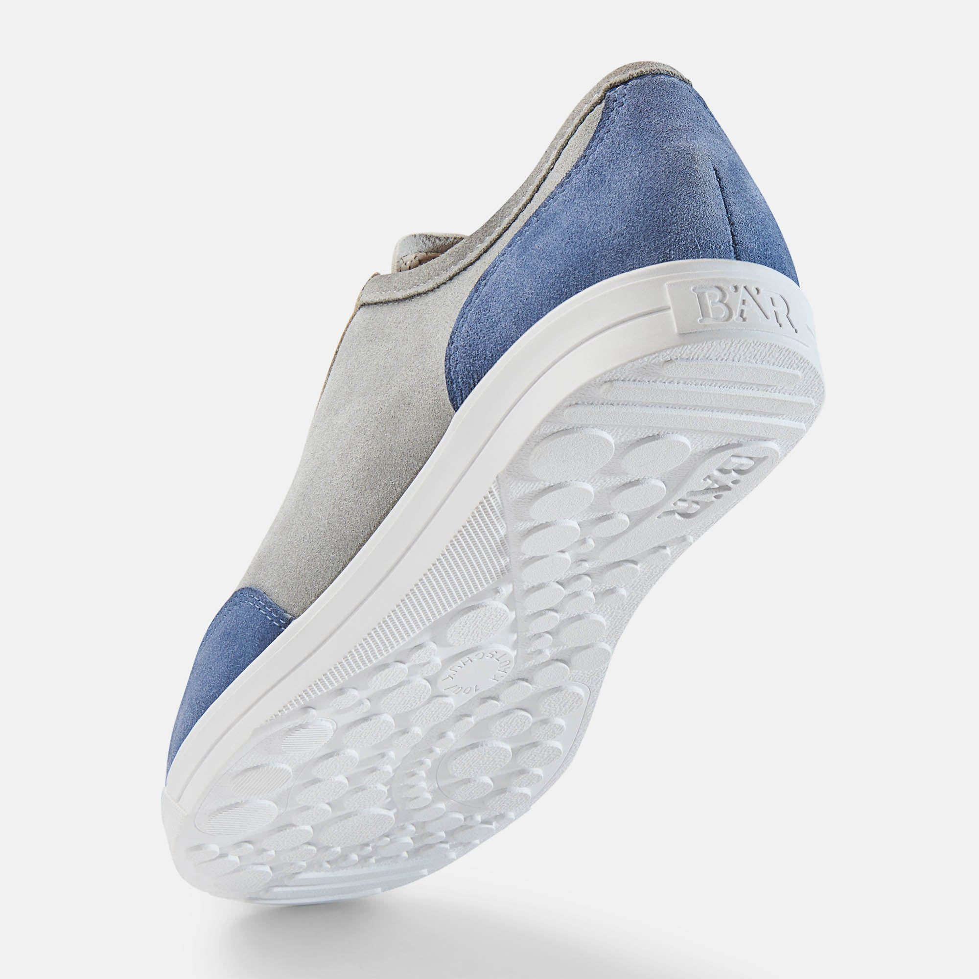 Grauer, blauer und beiger Schuh, Unteransicht. Weiße Sohle mit Muster. BÄR-Logo auf der Ferse.