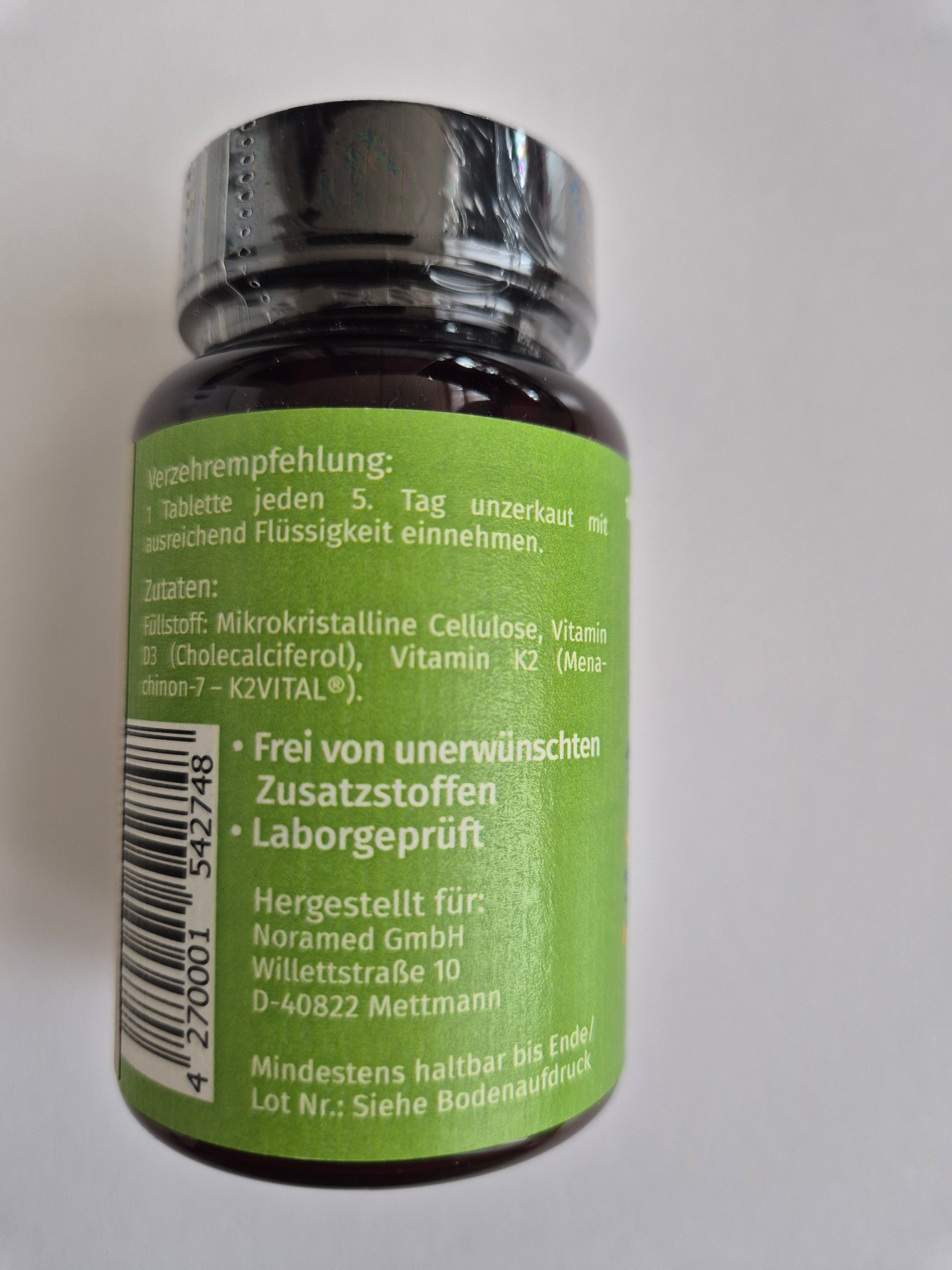 Rückseite einer Flasche. Grünes Etikett mit Text: 'Verzehrempfehlung', 'Zutaten', 'Frei von...', 'Laborgeprüft'.