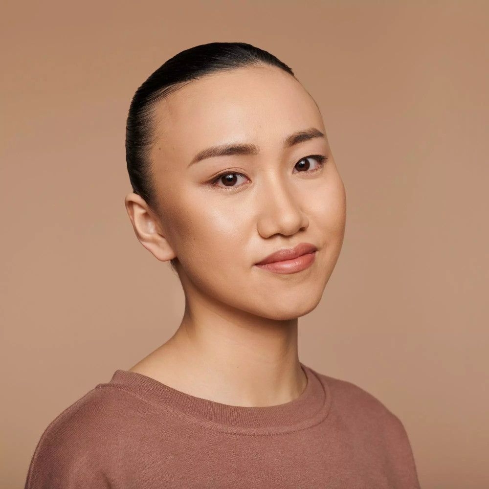 Porträt einer Frau mit Foundation. Gleichmäßiger Hautton. Glatte Oberfläche. Auf hellem Hintergrund.