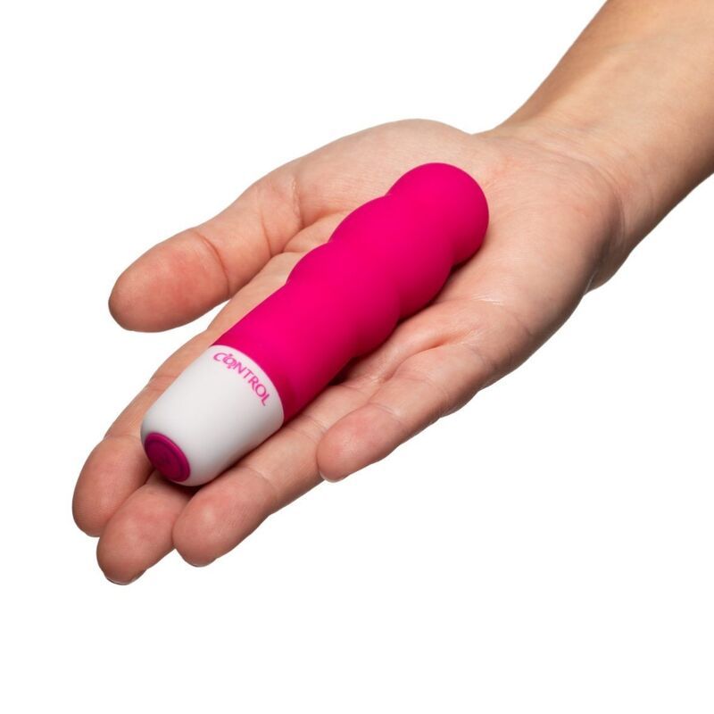 Pinker Mini-Stimulator mit geripptem Silikonschaft und weißem Griff, neben seiner Verpackung.