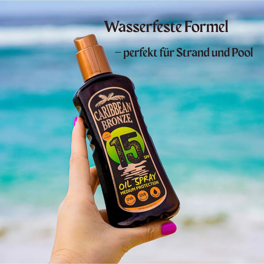 Braune Flasche in Hand. Aufschrift: Caribbean Bronze, 15 SPF, Oil Spray, Medium Protection. Text: Wasserfeste Formel.