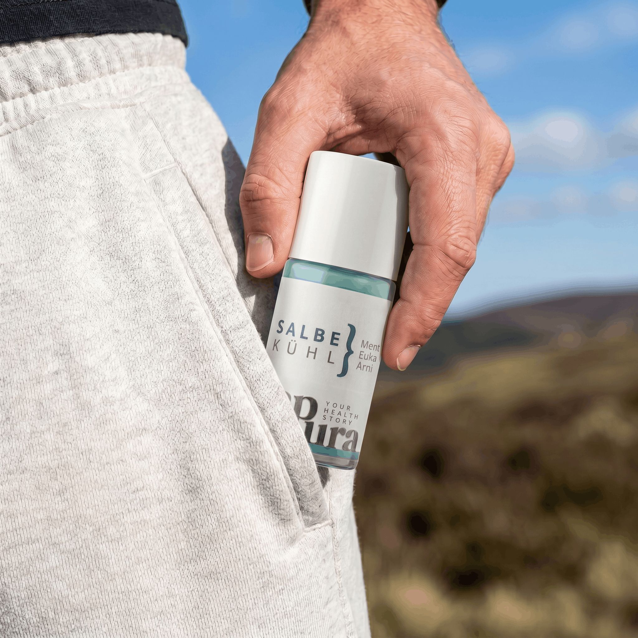 Hand steckt sapura health® Kühlgel Roll-On in eine Hosentasche.