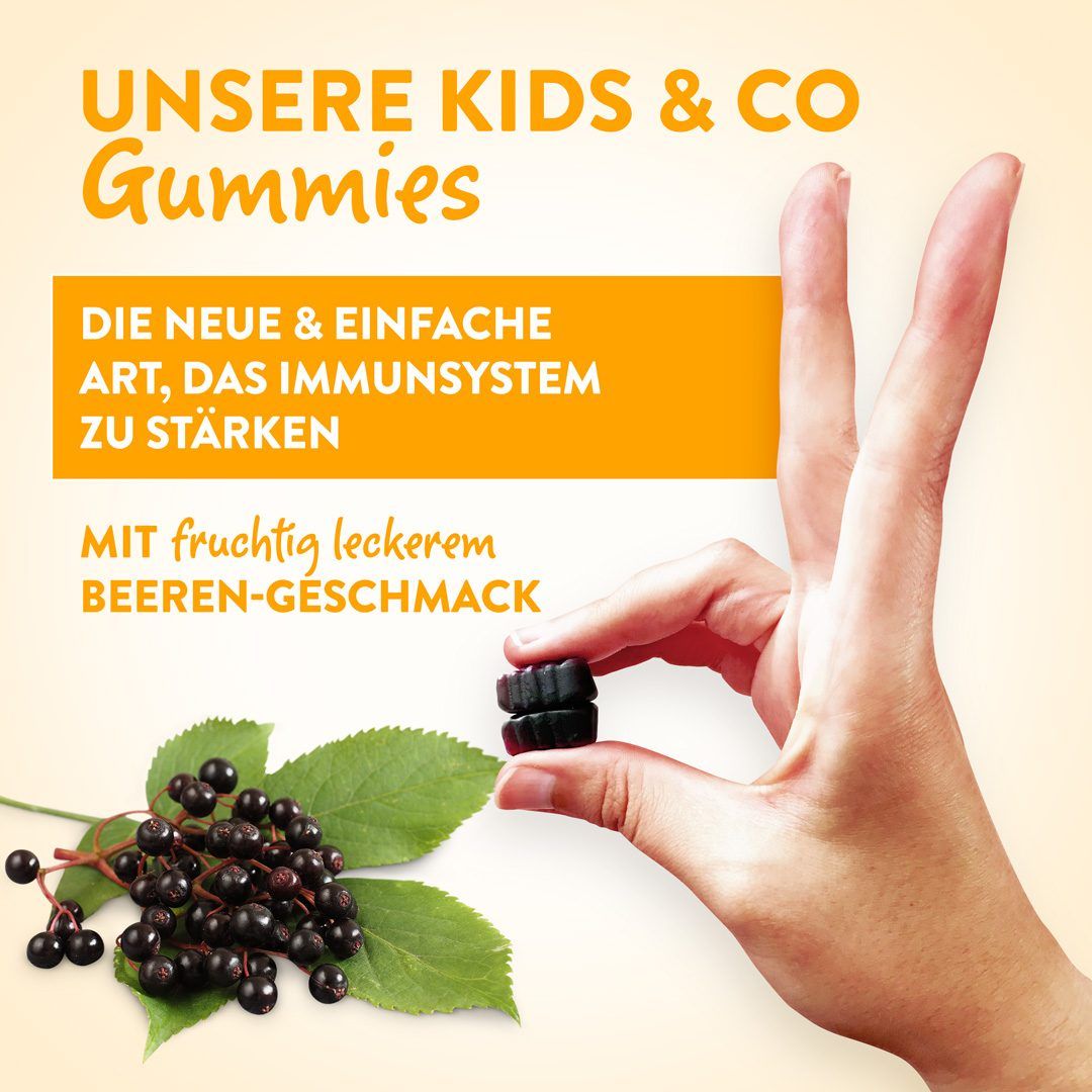 Hand hält zwei schwarze Gummibärchen. Unten: Holunderbeeren und Blätter. Text: 'UNSERE KIDS & CO Gummies'.