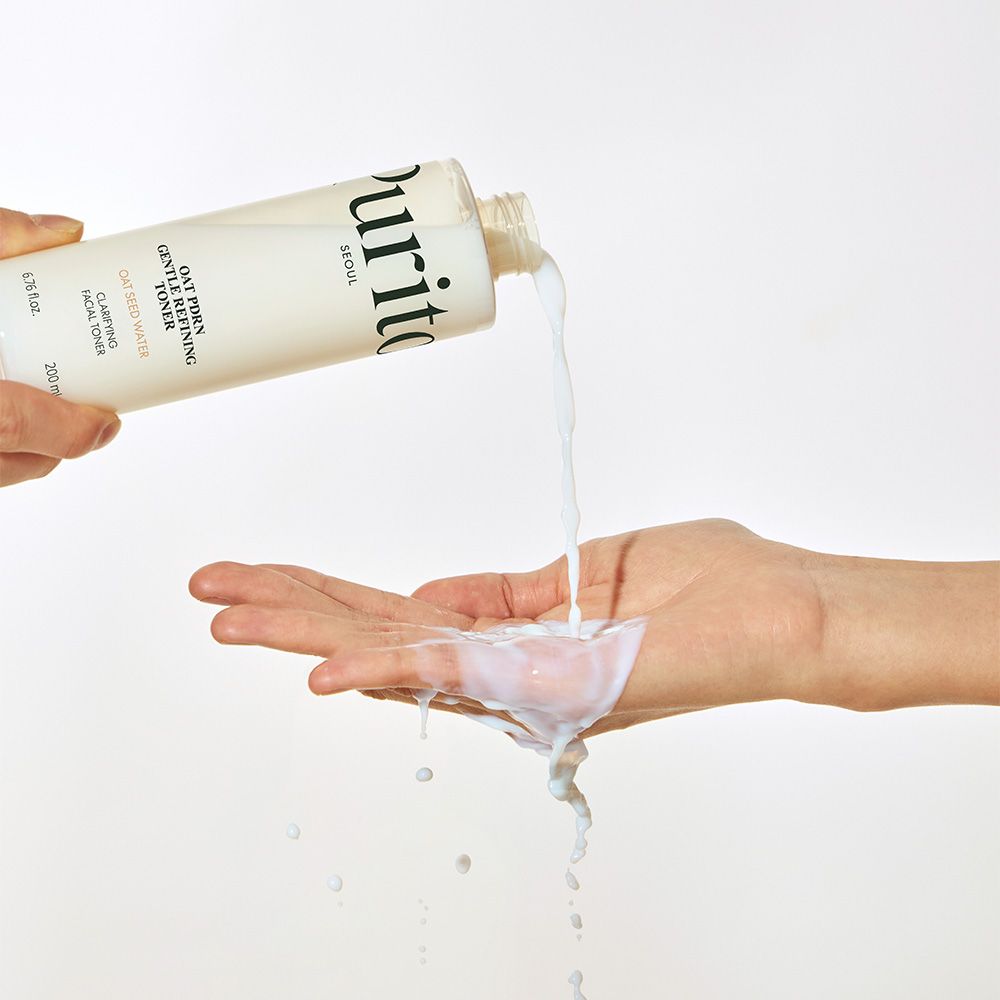Flüssigkeit wird aus einer Purito-Flasche in eine Handfläche gegossen.
