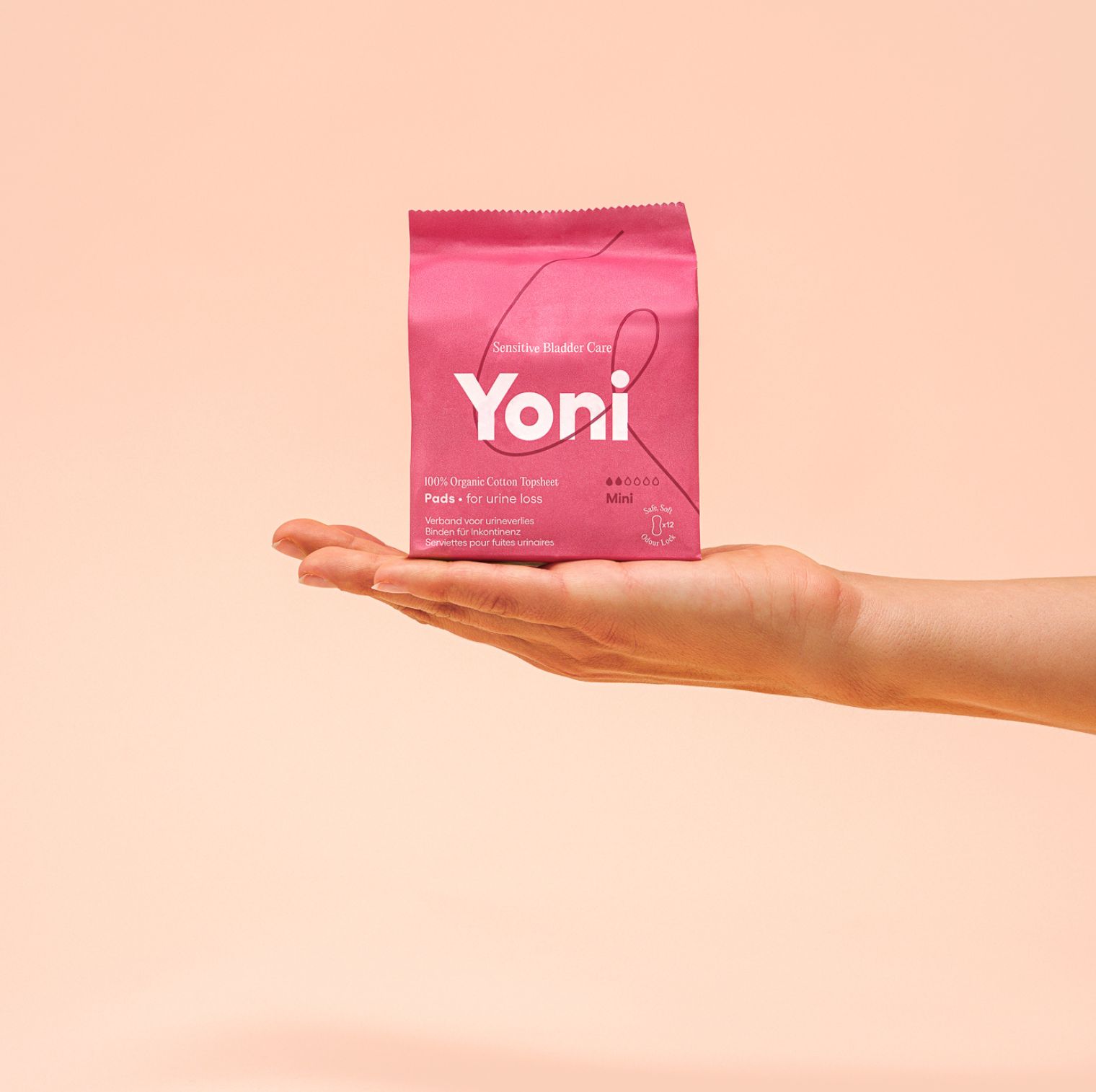 Rosa Verpackung mit Produktnamen Yoni. Aufschrift: Pads für Urinverlust. Gehalten von einer Hand.