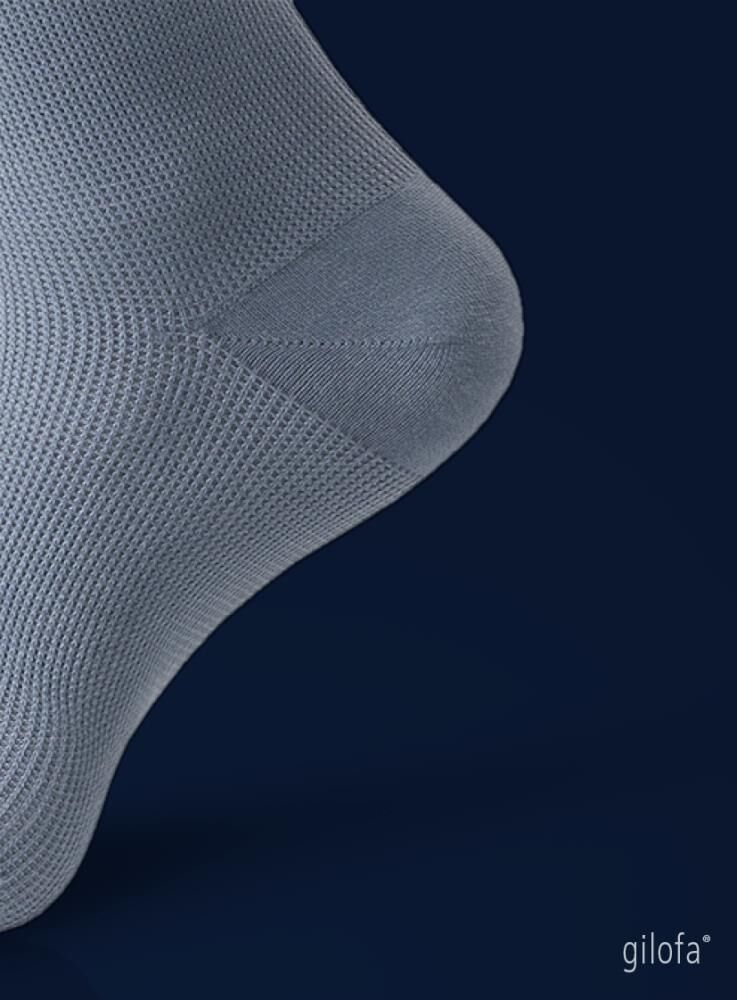 Hellgrauer Kompressionsstrumpf, Detail des Knöchels. Feines Maschenmuster. Marke: gilofa.