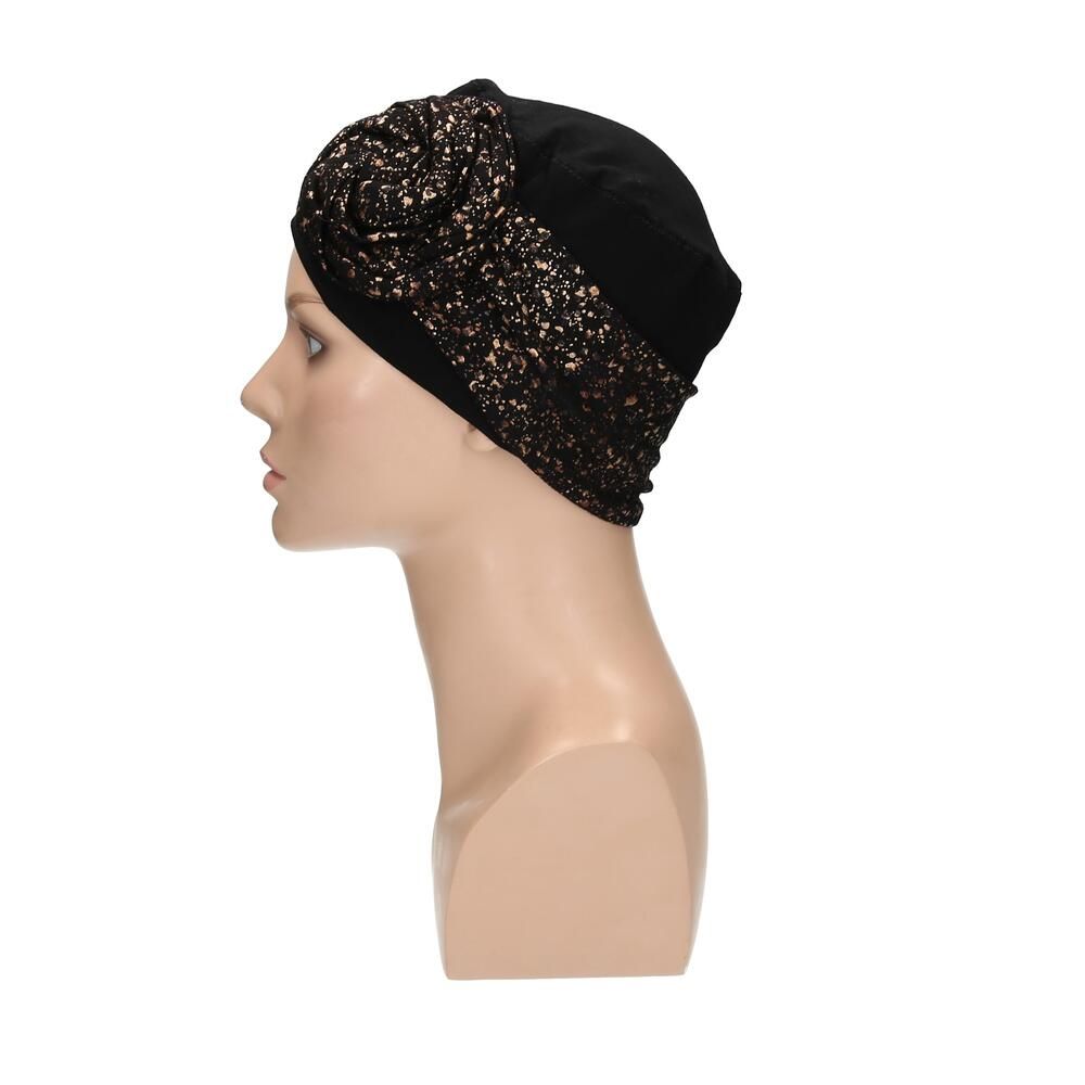 Schwarzer Turban mit goldfarbenem Muster auf einer Schaufensterpuppe. Seitenansicht.