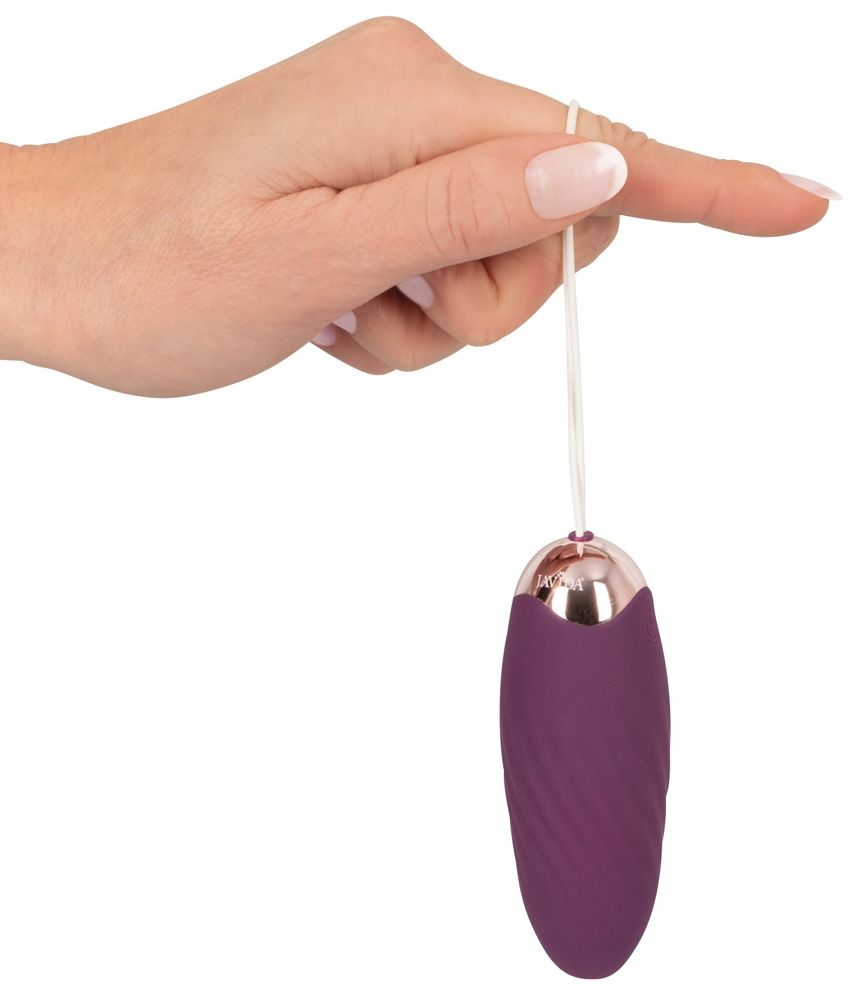 Javida Shaking Love Ball an Schnur, gehalten von Finger. Lila, oval, goldfarbener Abschluss.