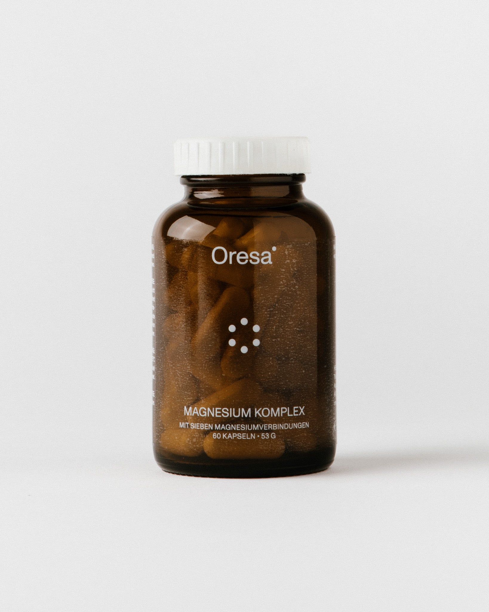 Braune Glasflasche mit weißem Deckel, gefüllt mit Kapseln. Aufschrift: Oresa Magnesium Komplex.