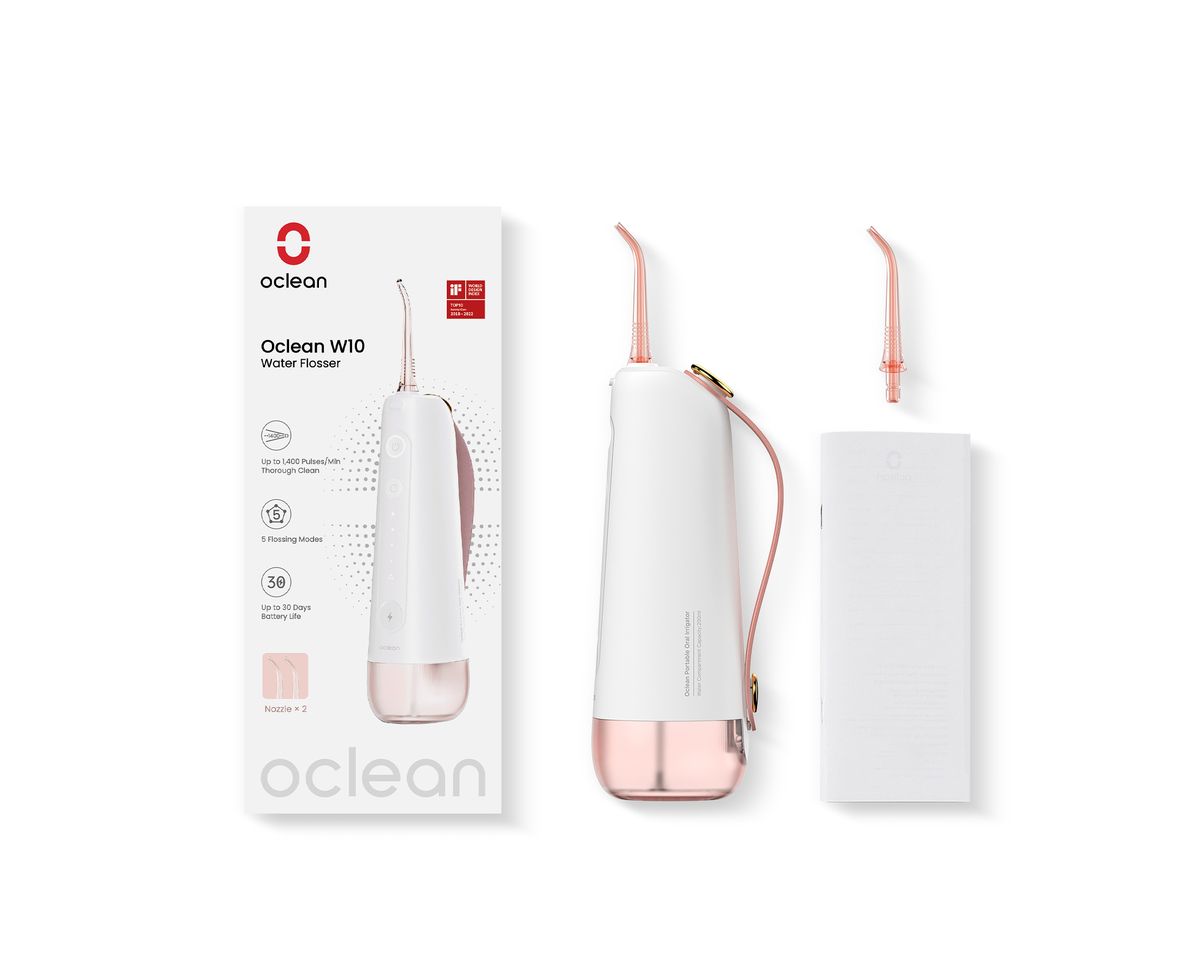 Oclean W10 Munddusche mit Verpackung und Zubehör. Weiß-rosa Gerät, zwei Düsen, weißes Ladegerät. Verpackung mit Produktname.