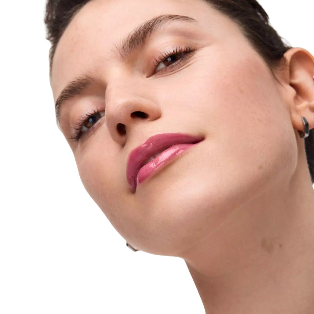 Nahaufnahme einer Frau mit glänzendem, pinkem Lippenstift.