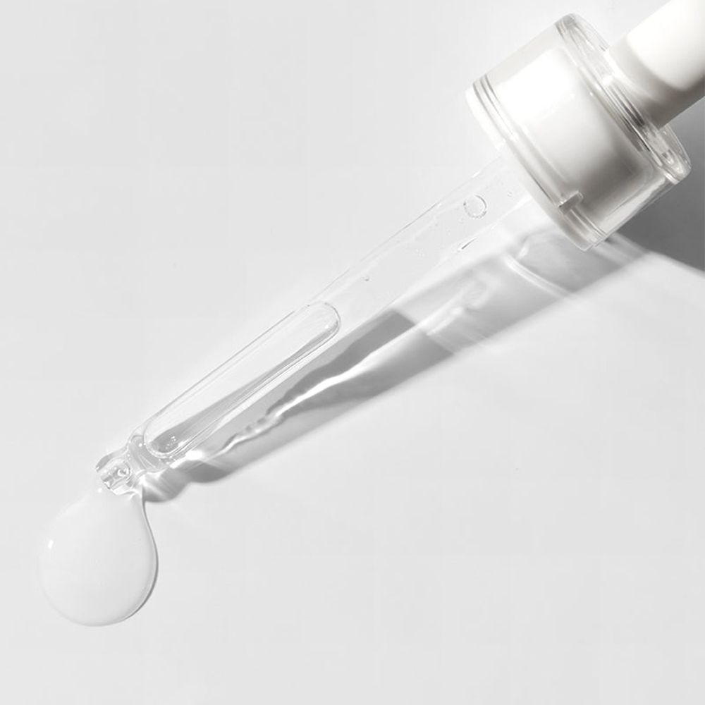 Tropfen COSRX Triple Hyaluronic Moisture Ampoule fallen von der Pipette.