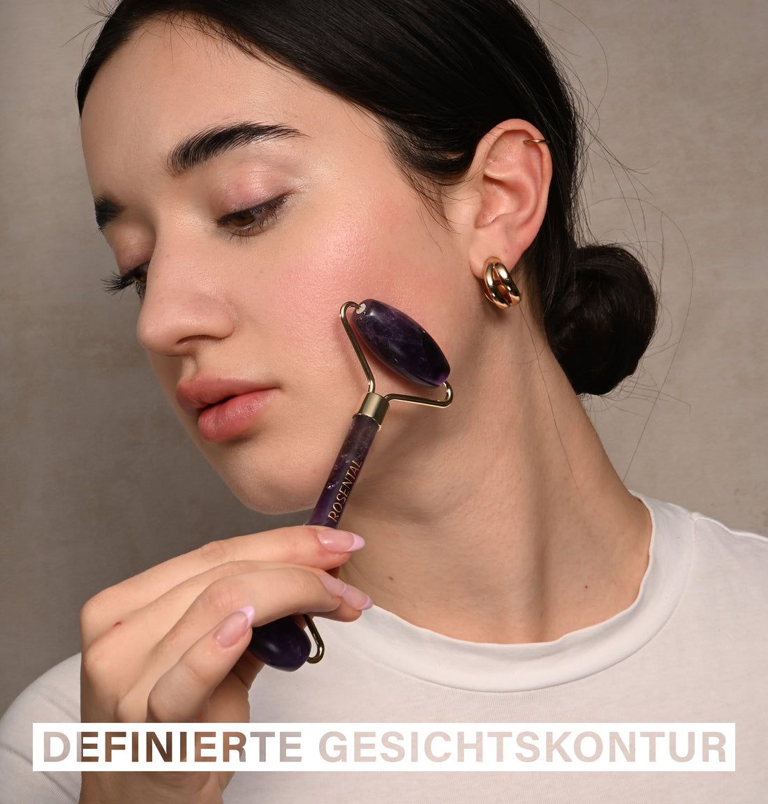 Frau verwendet einen Amethyst Roller auf ihrer Wange. Auf dem Griff steht Rosental.