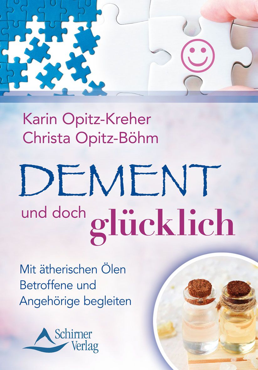 Buchcover: Titel "Dement und doch glücklich". Autoren: Karin Opitz-Kreher, Christa Opitz-Böhm. Verlag: Schirner. Abgebildet sind Puzzleteile und Fläschchen.