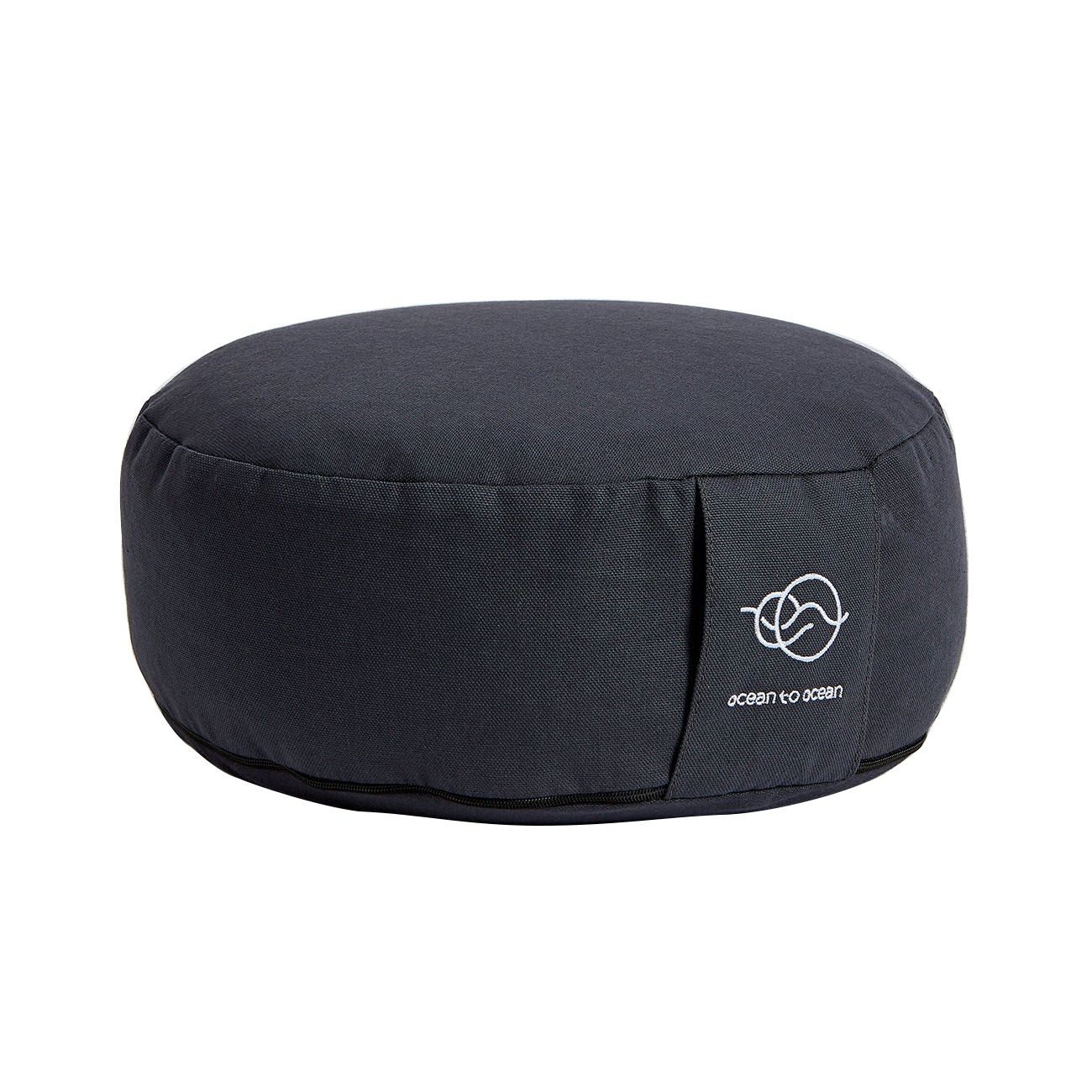 Rundes, dunkelgraues Meditationskissen. Auf der Seite befindet sich ein Etikett mit Logo und Schriftzug.