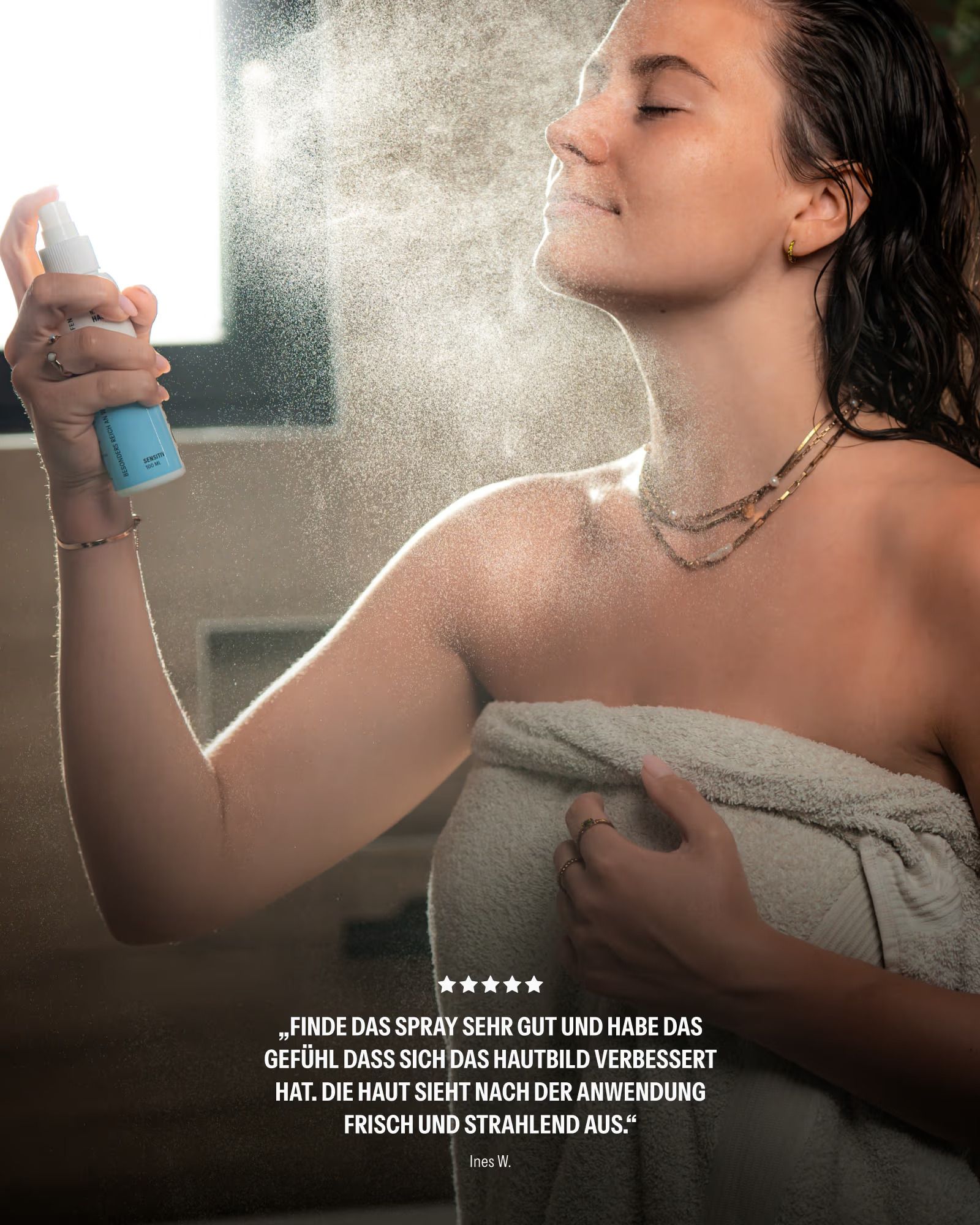 Frau mit Handtuch auf dem Kopf sprüht SOURCE LAB Mineralisches Hautspray ins Gesicht.