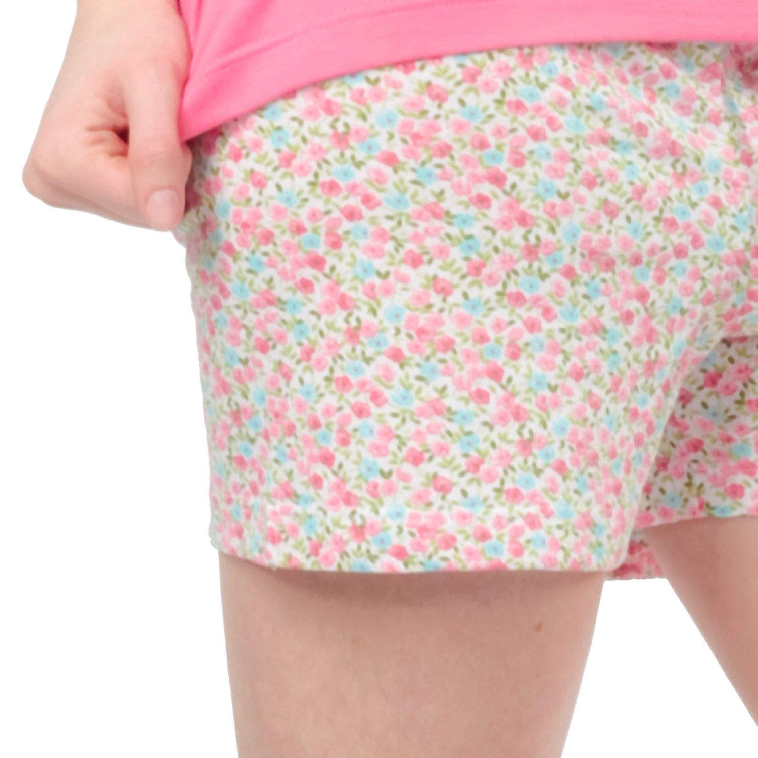 Primo piano dei pantaloncini di un pigiama. Fantasia floreale rosa e blu su sfondo bianco.