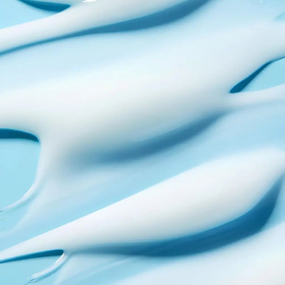 Weiße Creme-Textur auf blauem Hintergrund.