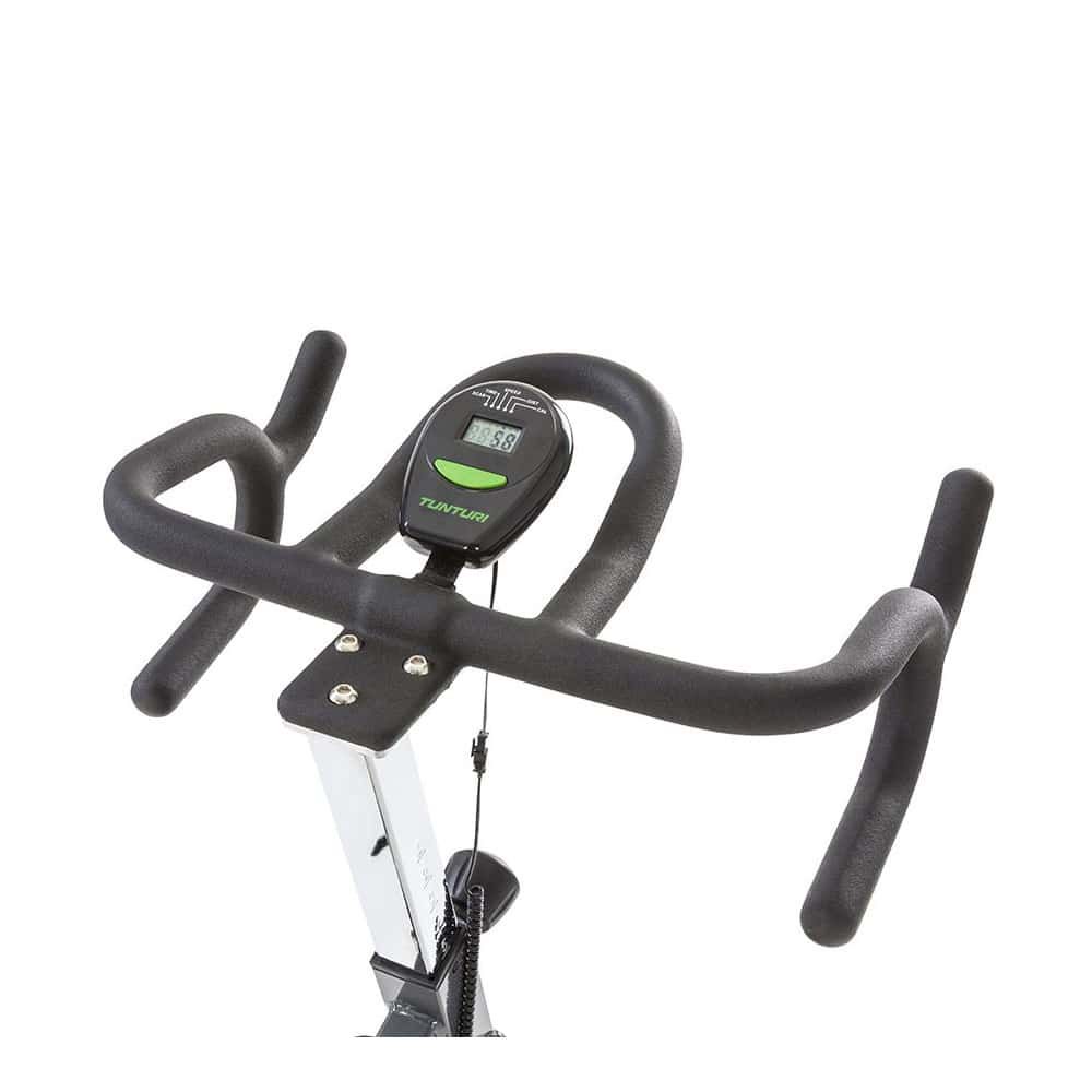 Lenker eines Indoor Cycles. Der Lenker ist schwarz und gebogen. Der Trainingscomputer mit Anzeige ist sichtbar. Der Markenname Tunturi ist sichtbar.